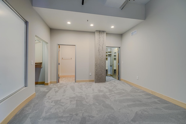 unfurnished bedroom with a spacious closet, visible vents, baseboards, carpet floors, and recessed lighting