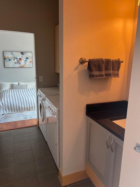 interior space with tile patterned floors, baseboards, and washing machine and dryer