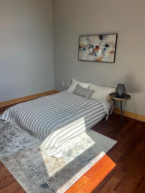 bedroom with baseboards and wood finished floors