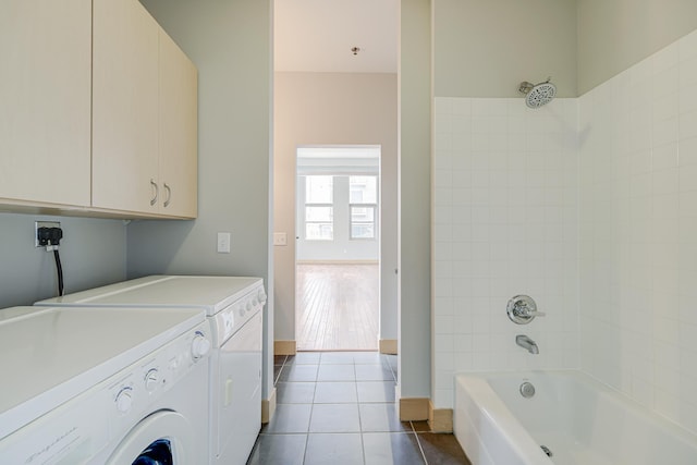 laundry room featuring laundry area, dark tile patterned flooring, washing machine and dryer, and baseboards