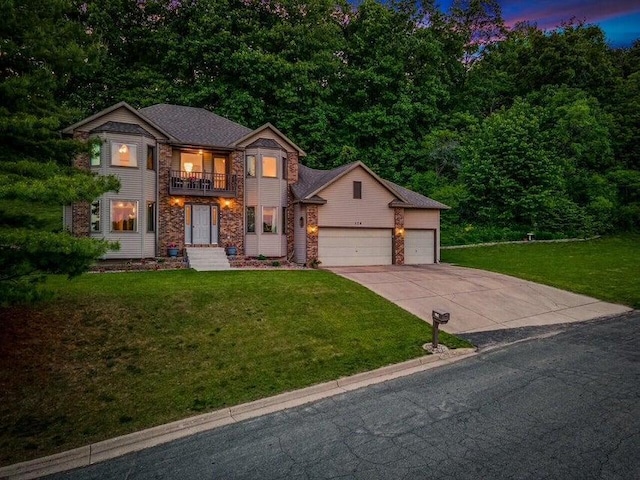 view of front facade with a garage, a lawn, driveway, and a balcony