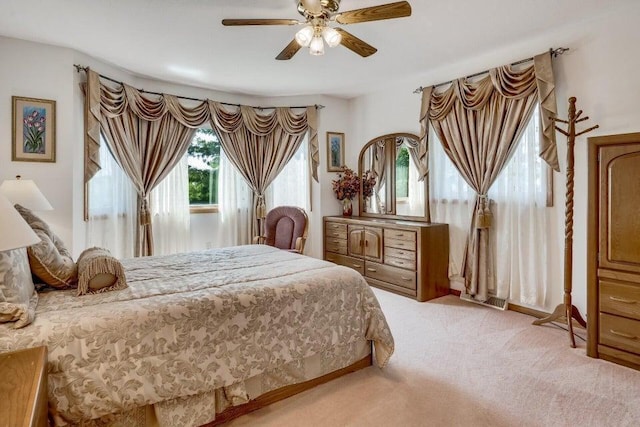 bedroom with a ceiling fan and light carpet