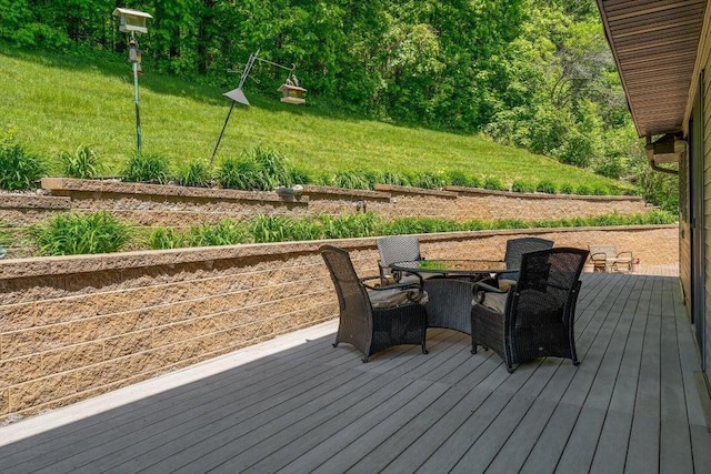 deck featuring outdoor dining space and a yard