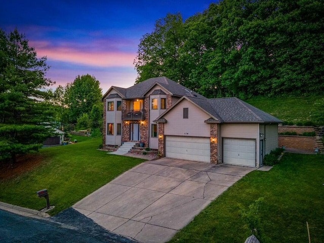 view of front of property featuring a balcony, an attached garage, concrete driveway, and a lawn