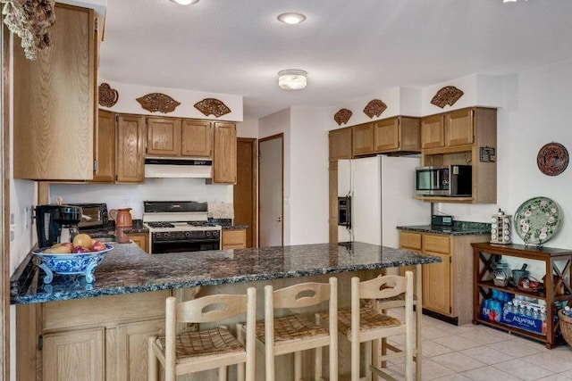 kitchen with range with gas stovetop, light tile patterned floors, a peninsula, white fridge with ice dispenser, and under cabinet range hood