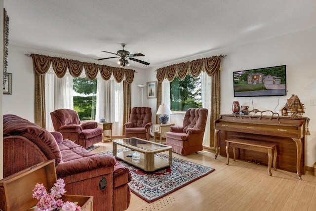 living area with plenty of natural light, light wood-type flooring, and ceiling fan