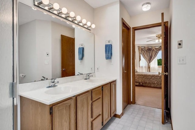 ensuite bathroom with double vanity, ensuite bath, a ceiling fan, and a sink