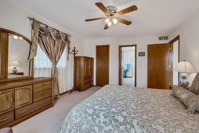 bedroom featuring light colored carpet, visible vents, and ceiling fan