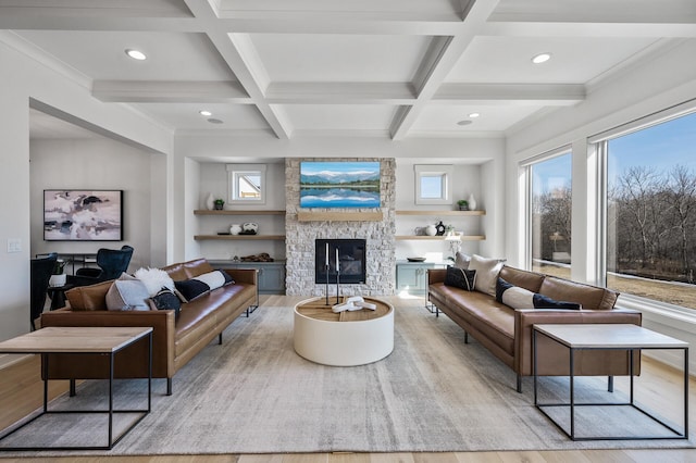 living room featuring beam ceiling, coffered ceiling, a fireplace, and light wood-type flooring