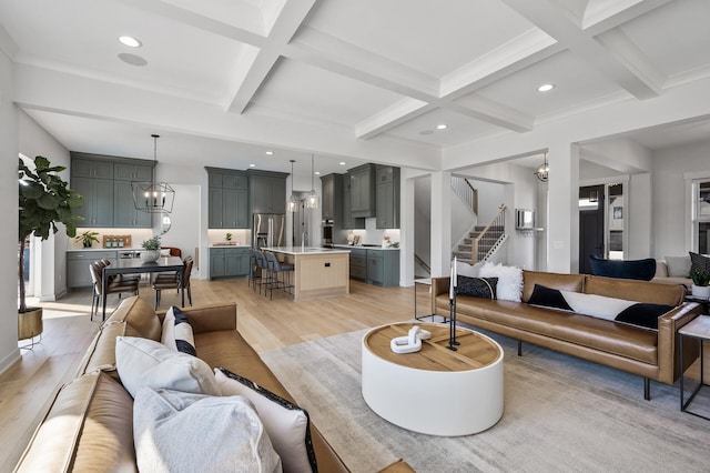 living area with beam ceiling, coffered ceiling, stairs, and light wood-type flooring