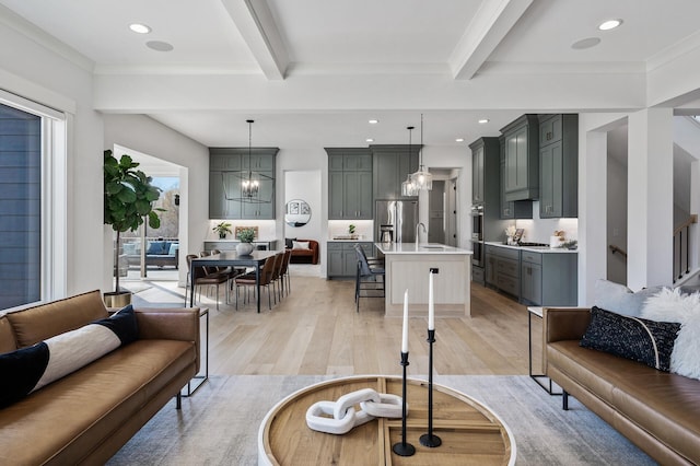 living area with beam ceiling, recessed lighting, an inviting chandelier, and light wood-style floors