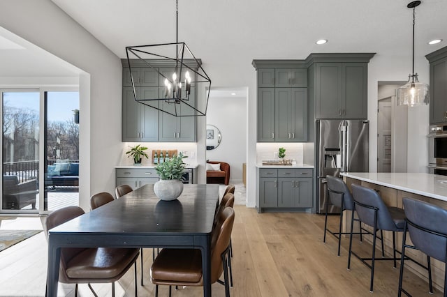 dining space featuring recessed lighting, light wood-style floors, and a chandelier