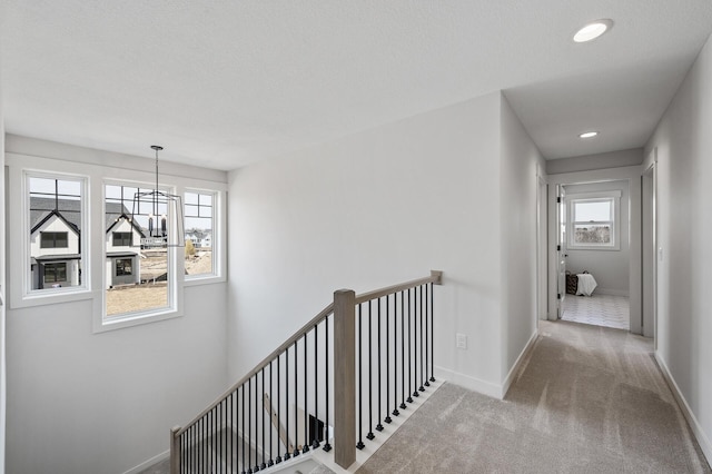 hall with baseboards, a chandelier, an upstairs landing, carpet flooring, and recessed lighting