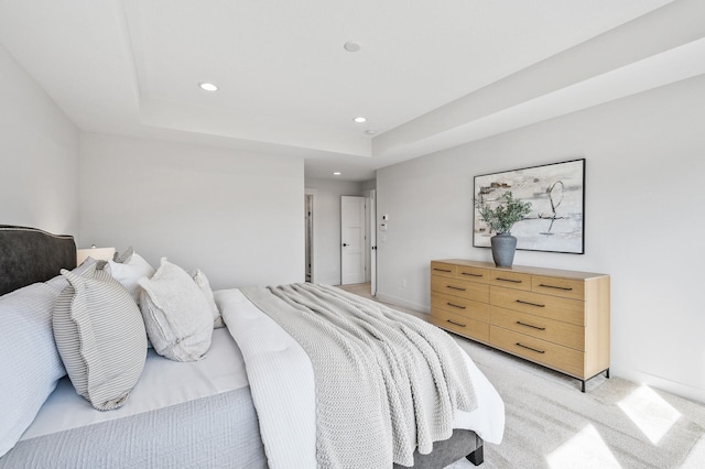 bedroom with light carpet, recessed lighting, baseboards, and a tray ceiling