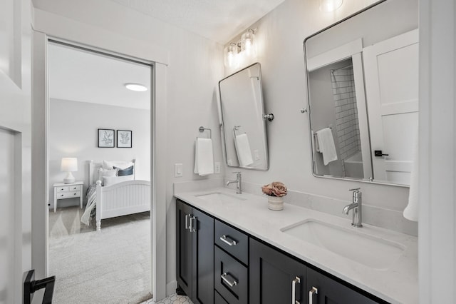 ensuite bathroom featuring a sink, ensuite bath, and double vanity