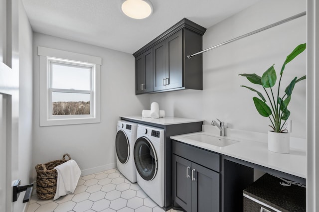 laundry area with cabinet space, washer and dryer, baseboards, and a sink