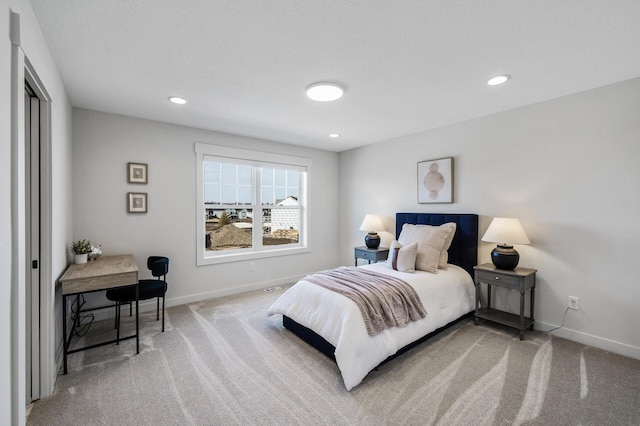 bedroom with light carpet, recessed lighting, and baseboards