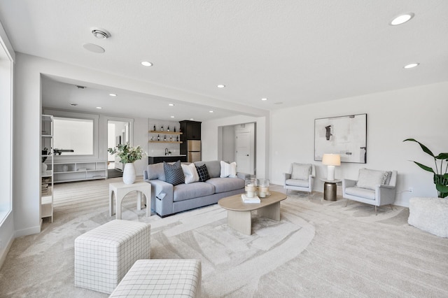 living area with a bar, recessed lighting, and light colored carpet