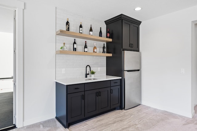 bar with recessed lighting, freestanding refrigerator, a sink, decorative backsplash, and indoor wet bar