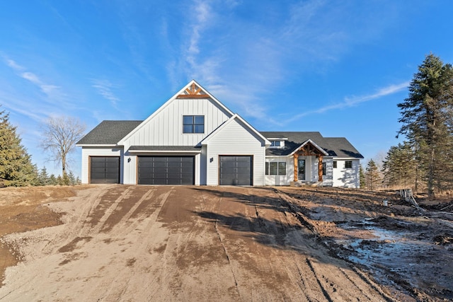 modern farmhouse with a garage, board and batten siding, and driveway