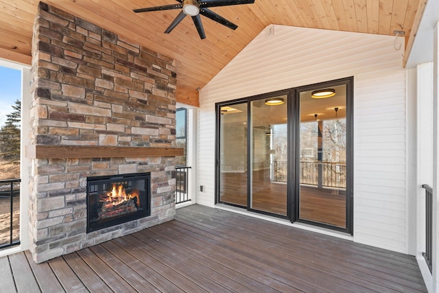 wooden terrace featuring a ceiling fan and an outdoor stone fireplace