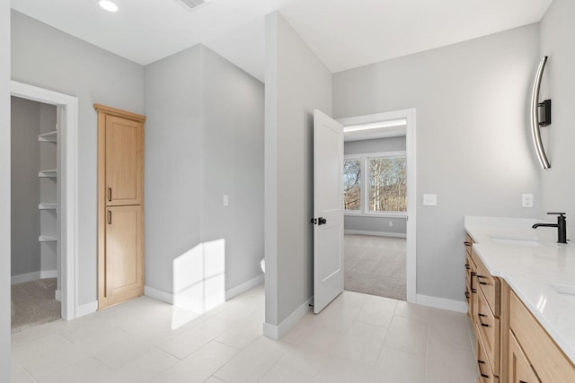 bathroom with visible vents, baseboards, double vanity, a sink, and toilet