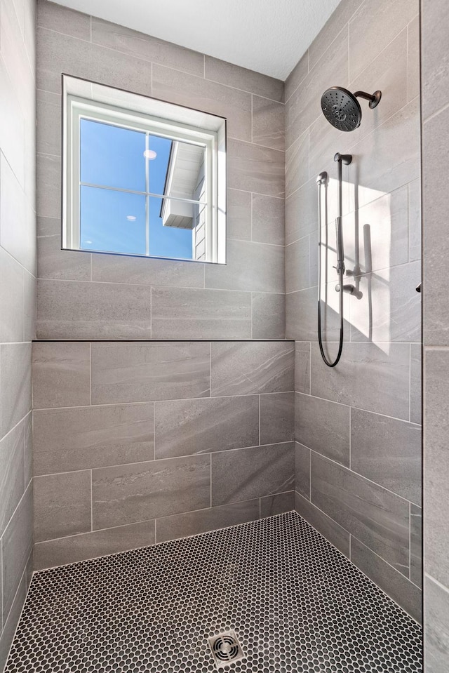 full bath featuring a wealth of natural light and a tile shower