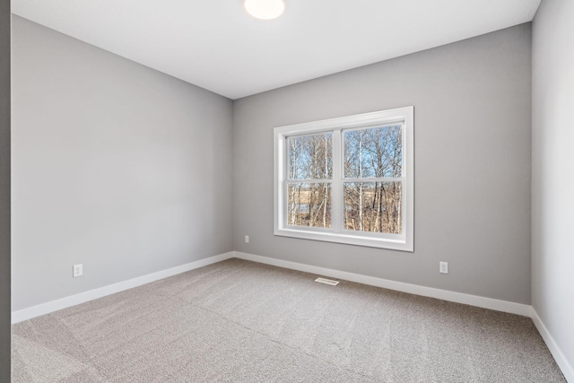 carpeted empty room featuring visible vents and baseboards