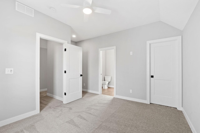 unfurnished bedroom with visible vents, baseboards, carpet flooring, and vaulted ceiling