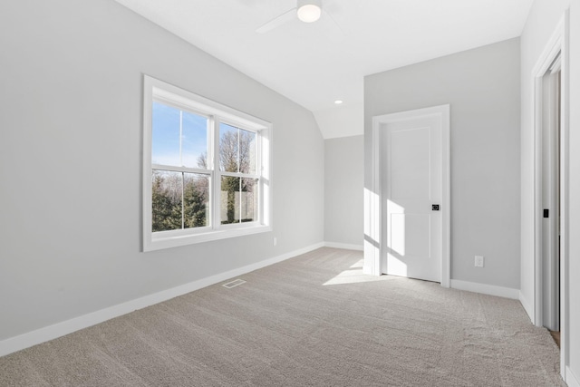 unfurnished bedroom with visible vents, baseboards, carpet, and vaulted ceiling