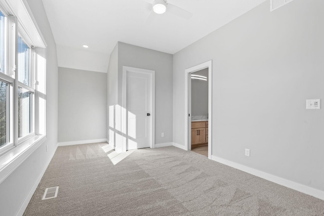 unfurnished bedroom with connected bathroom, baseboards, visible vents, and light carpet