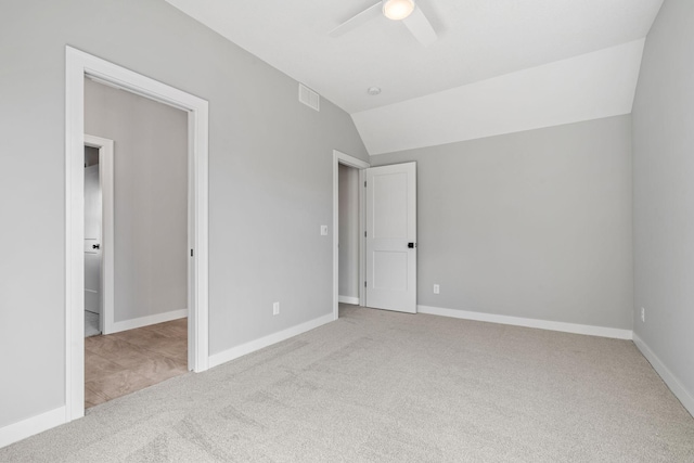 unfurnished bedroom featuring visible vents, lofted ceiling, carpet, baseboards, and ceiling fan