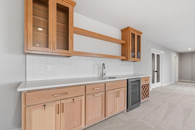 kitchen with wine cooler, open shelves, light countertops, and a sink