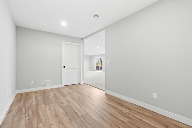 empty room featuring recessed lighting, light wood-style floors, visible vents, and baseboards