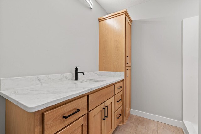 bathroom with tile patterned flooring, vanity, and baseboards