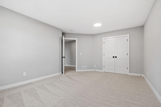 unfurnished bedroom with a closet, baseboards, visible vents, and carpet floors