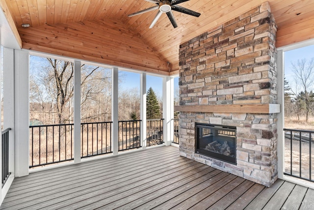 exterior space with a ceiling fan, lofted ceiling, wood ceiling, and an outdoor stone fireplace