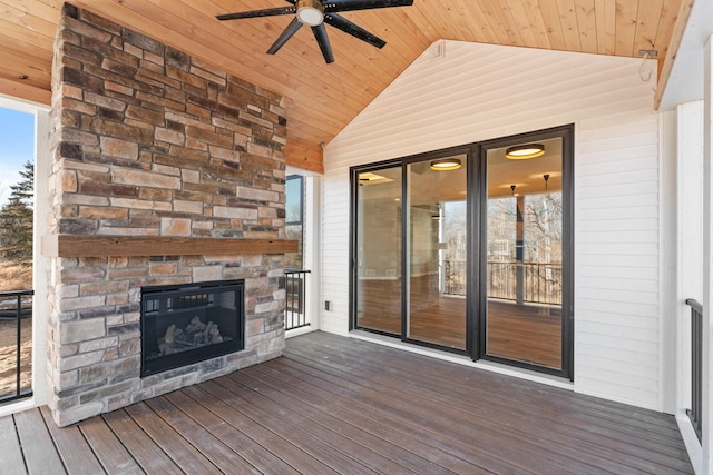 deck with ceiling fan and an outdoor stone fireplace