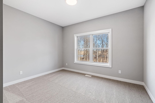 carpeted empty room with visible vents and baseboards