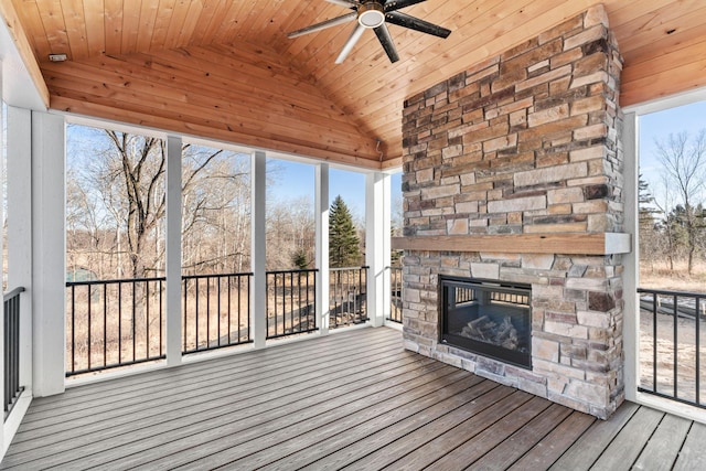 exterior space featuring wood ceiling, an outdoor stone fireplace, ceiling fan, and vaulted ceiling