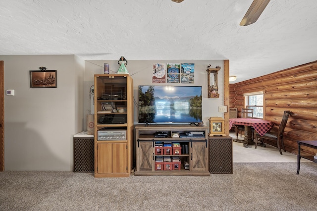 carpeted living area with a textured ceiling and a ceiling fan