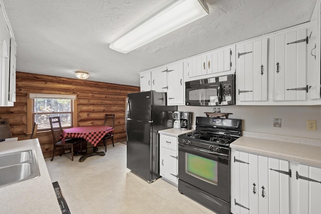 kitchen with a sink, black appliances, light countertops, a textured ceiling, and white cabinetry