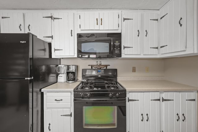 kitchen with black appliances, white cabinets, and light countertops