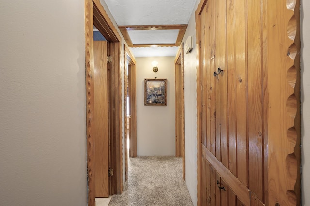 corridor with light colored carpet and a textured ceiling