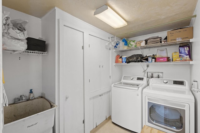 clothes washing area with laundry area, washer and dryer, and a sink