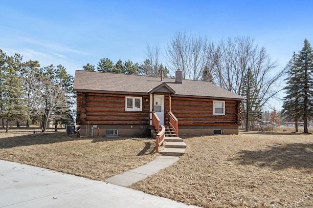 cabin featuring log siding, central air condition unit, and roof with shingles