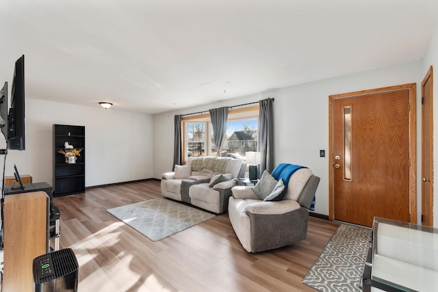 living area featuring baseboards and wood finished floors