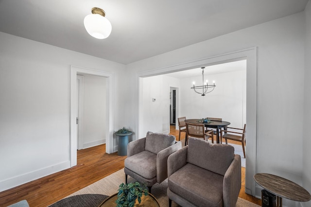 living room with wood finished floors, baseboards, and a chandelier