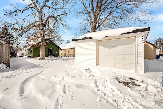 snow covered garage with a detached garage