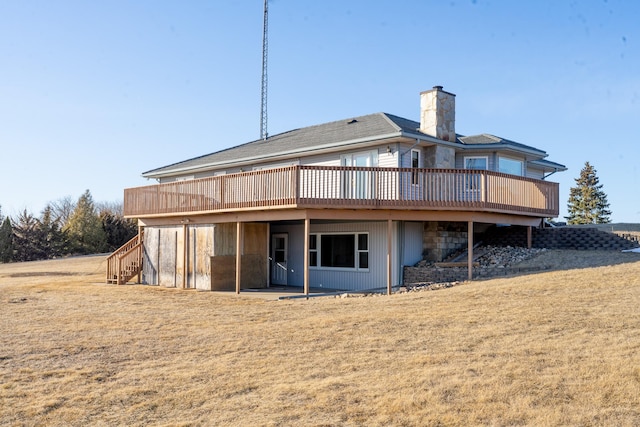 rear view of property with stairs, a wooden deck, a lawn, and a chimney